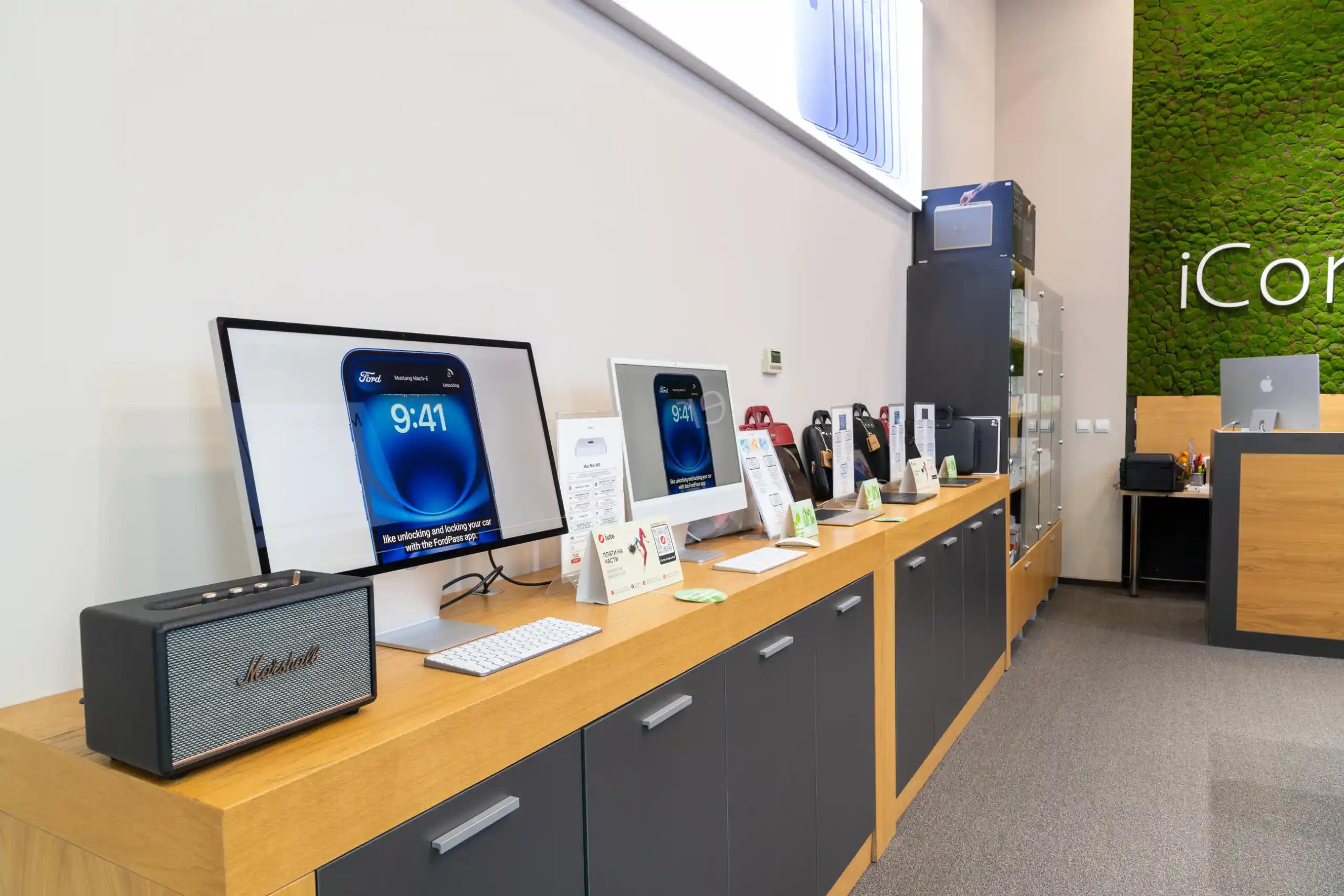 Модерен магазин на iCorner в Bulgaria Mall, София, с изложени iMac компютри, iPhone телефони, Marshall високоговорител
