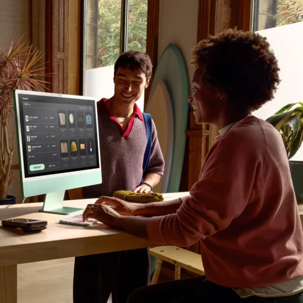 Двама души на бюро с iMac
